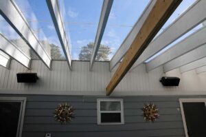 Clear awning roof with plexiglass panels over pool and concert speakers