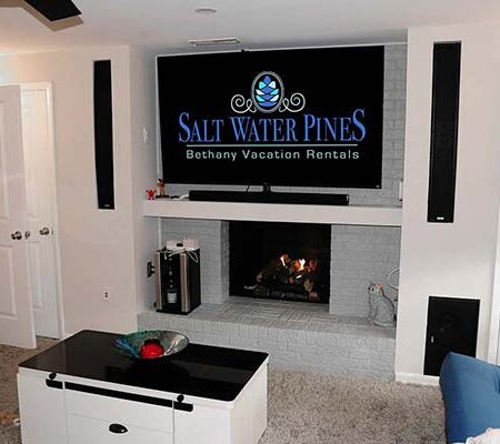 Family room with large TV, surround sound, gas fireplace, karaoke machine, and Atari game consoles