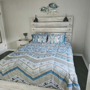 Bedroom 1 with queen sized adjustable bed, large LED TV, and slider to covered outdoor sitting area and walkaround deck to back