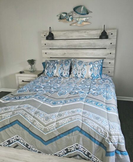 Bedroom 1 with queen sized adjustable bed, large LED TV, and slider to covered outdoor sitting area and walkaround deck to back