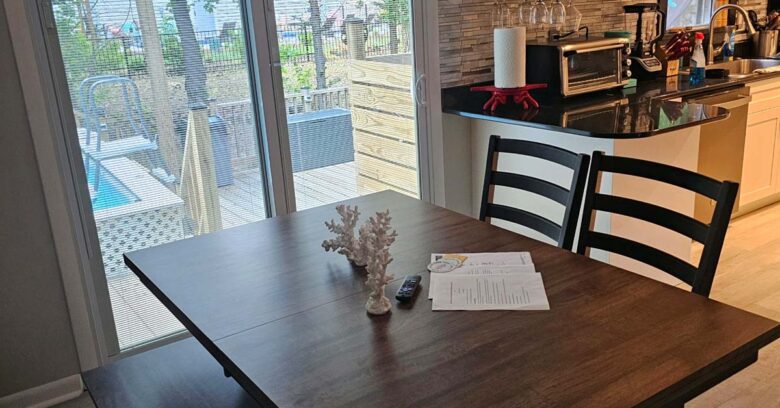 Dining room opens to kitchen with view of pool