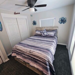 Bedroom 2 large screen HDTV, electric fireplace, ceiling fan, and slider to pool area