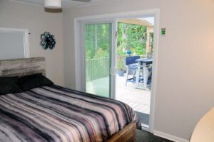 Bedroom 2 has a view of pool area and rear deck with built in privacy binds inside the sliding doors.